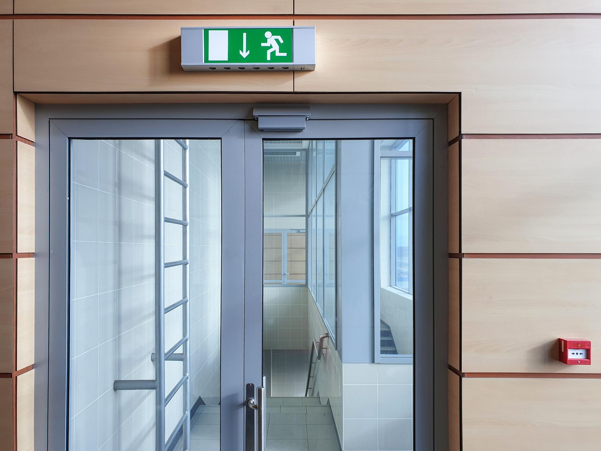 Emergency exit with glass door in airport office building. Emergency fire doors.